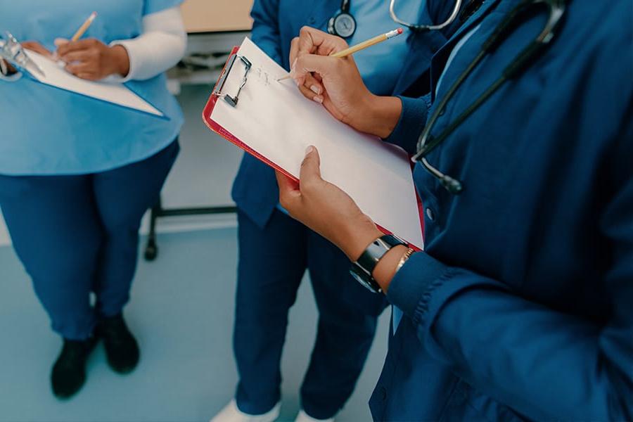 nursing hands on a clipboard