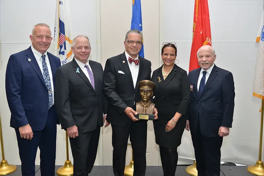 Group of veterans stand with award.